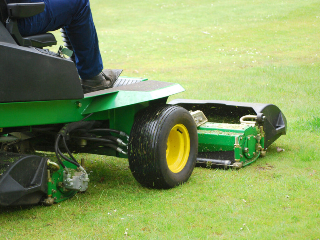 man cutting lawn with riding mower						
